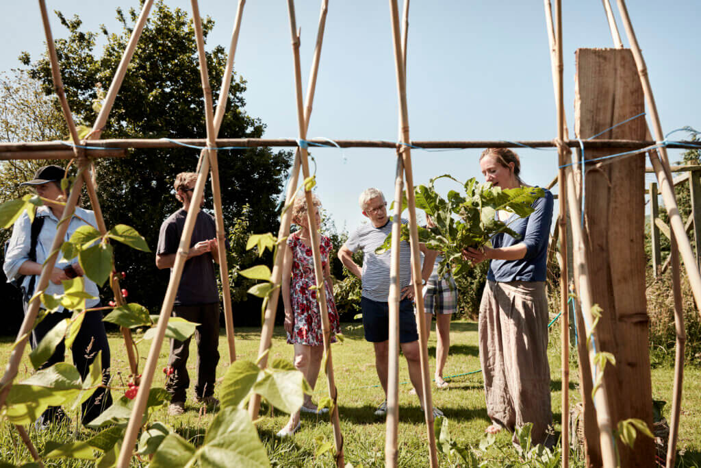 Gruppe aus Jung und Alt steht gemeinsam in einem Garten